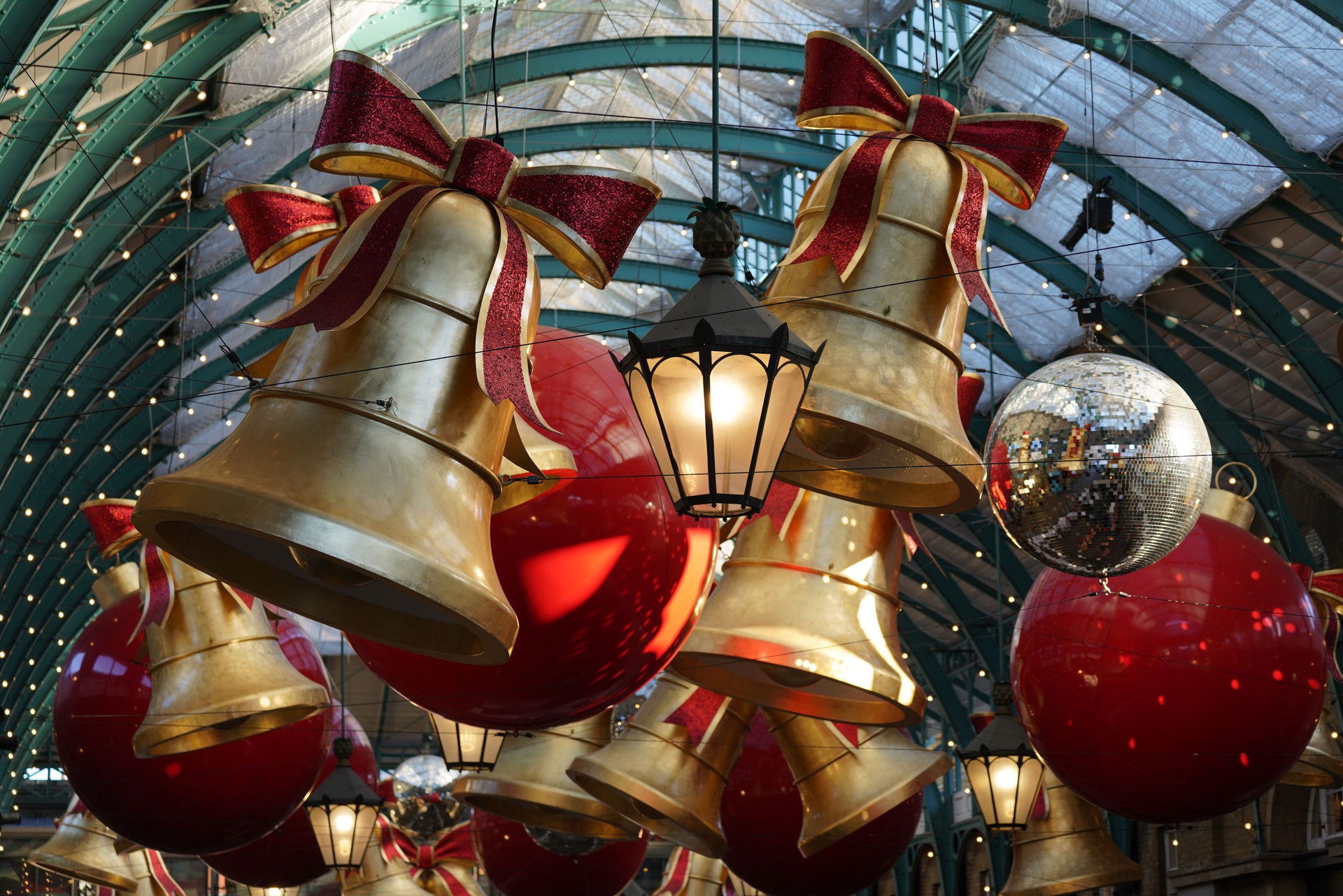 Covent Garden Market oversized decorative bells, Disco Balls, Christmas Lights, red bows Christmas decorations London England